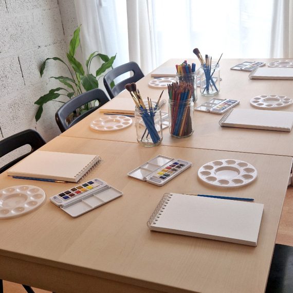 Vue d'ensemble de la table de travail et du matériel d'aquarelle installés pour accueillir les élèves de l'atelier libre d'aquarelle à L'Arbresle.